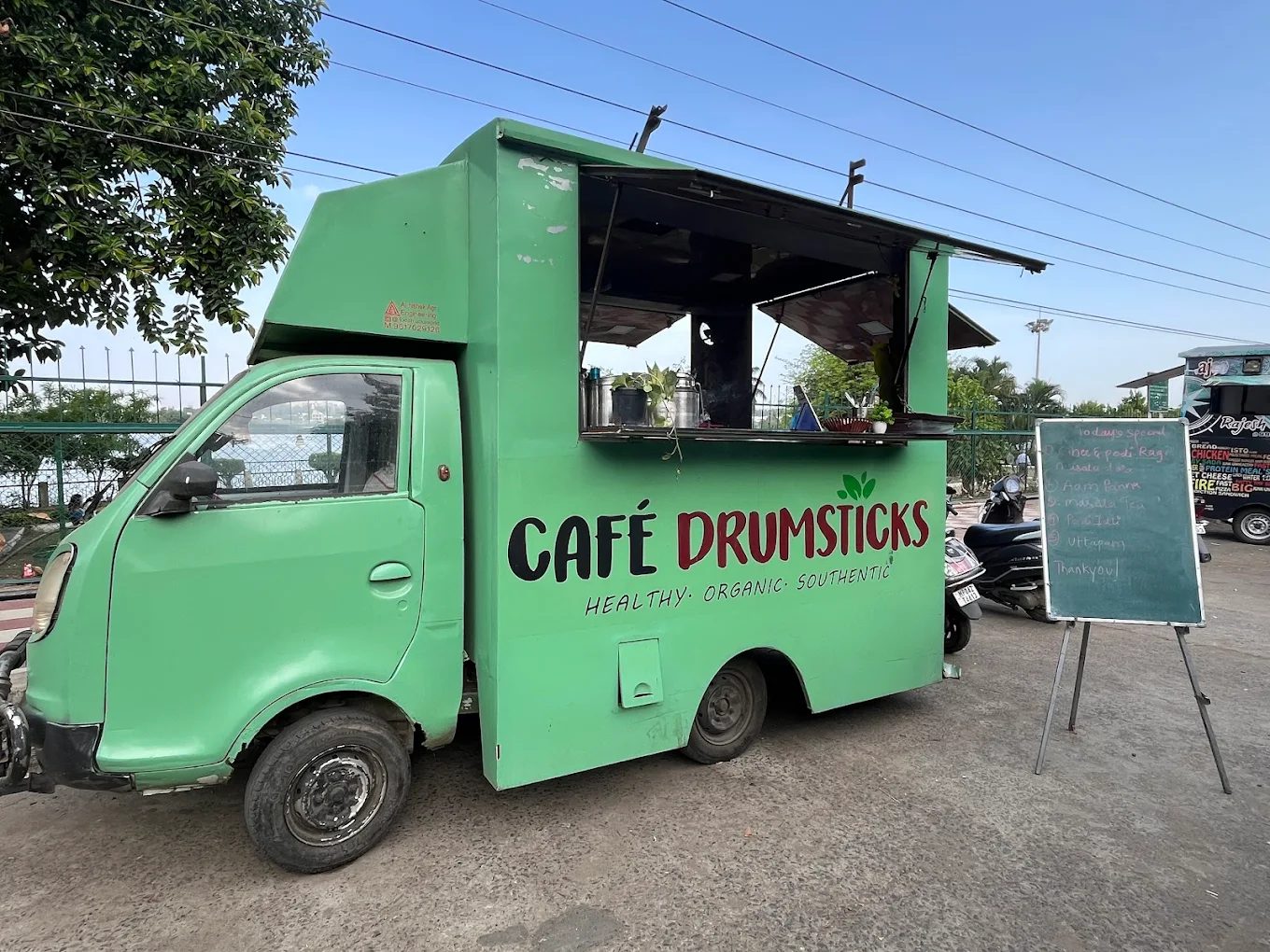 The Cafe Drumsticks food truck and open-air seating at dusk